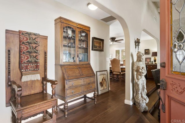 interior space with visible vents, arched walkways, dark wood finished floors, and ceiling fan