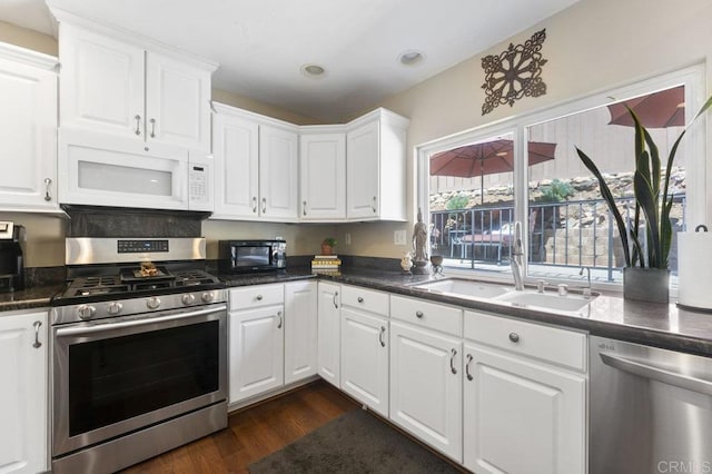 kitchen with a sink, dark wood finished floors, white cabinetry, and stainless steel appliances