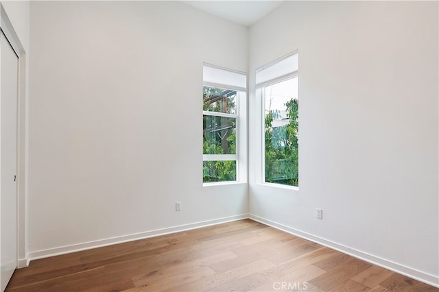unfurnished room featuring baseboards and wood finished floors