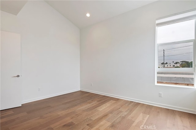 unfurnished room with light wood-style floors, recessed lighting, baseboards, and lofted ceiling