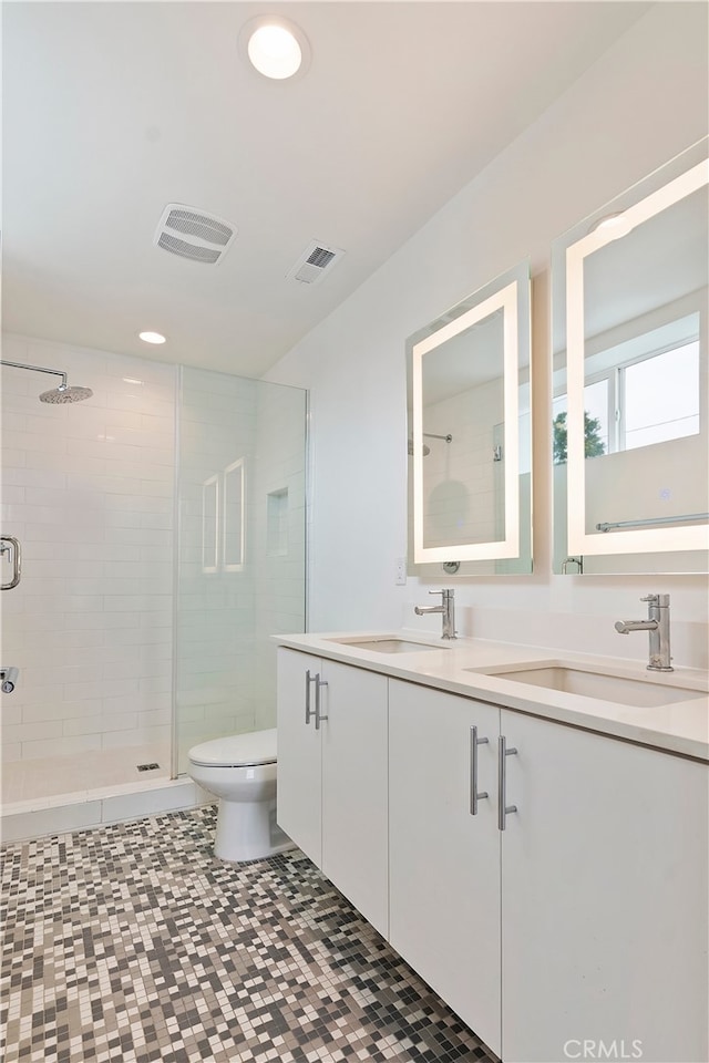 bathroom featuring a sink, a shower stall, toilet, and visible vents