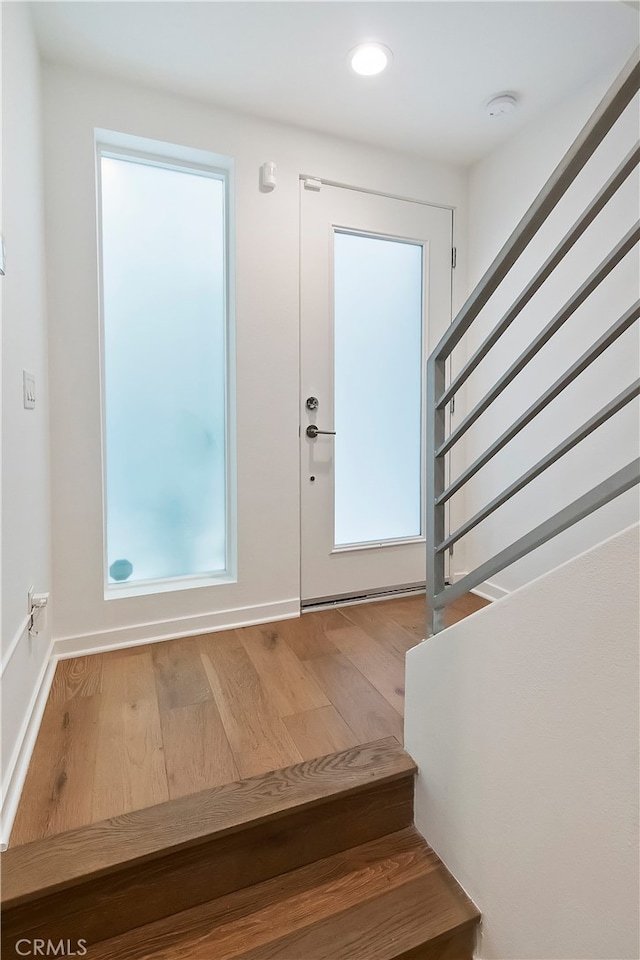 foyer with stairway, baseboards, recessed lighting, and wood finished floors