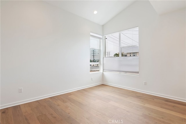 empty room with baseboards, recessed lighting, wood finished floors, and lofted ceiling