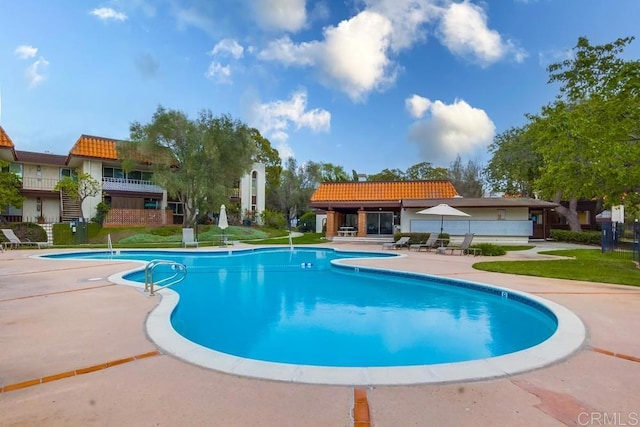 community pool with a yard and a patio area