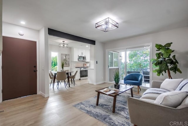 living room featuring baseboards and light wood-style flooring
