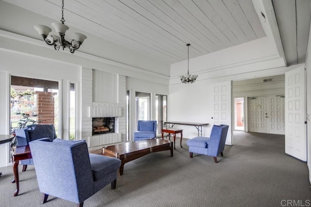 carpeted living area featuring visible vents, a brick fireplace, and a chandelier