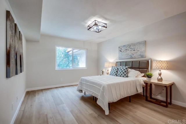 bedroom with baseboards and wood finished floors