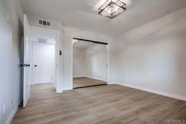 unfurnished bedroom featuring visible vents, baseboards, a closet, and light wood-type flooring
