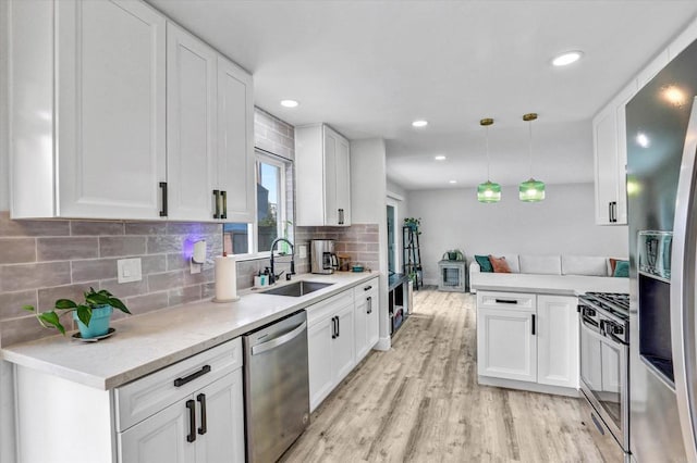 8394 Blue Lake Dr, San Diego, CA 92119 - kitchen featuring light countertops, white cabinets, a sink, backsplash, and stainless steel appliances