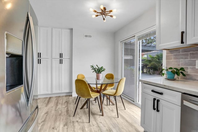 8394 Blue Lake Dr, San Diego, CA 92119 - dining room featuring a notable chandelier, visible vents, and light wood-type flooring