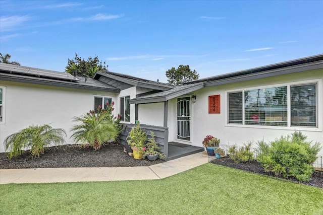 8394 Blue Lake Dr, San Diego, CA 92119 - entrance to property featuring roof mounted solar panels, stucco siding, and a yard