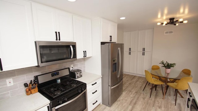8394 Blue Lake Dr, San Diego, CA 92119 - kitchen with visible vents, light countertops, white cabinets, tasteful backsplash, and appliances with stainless steel finishes