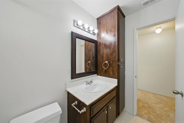 bathroom featuring toilet, tile patterned floors, visible vents, and vanity