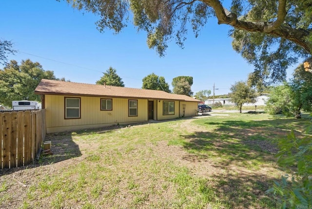 view of front of home featuring fence and a front lawn
