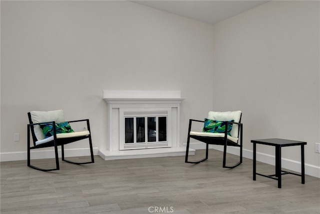 sitting room with baseboards and wood finished floors