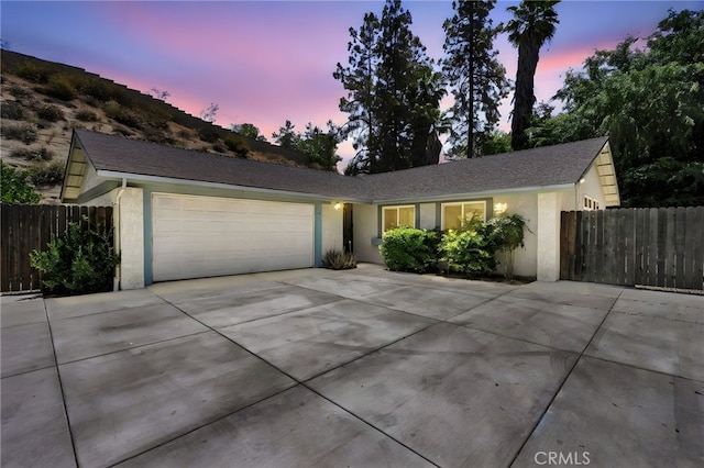 single story home featuring fence, stucco siding, an attached garage, and driveway