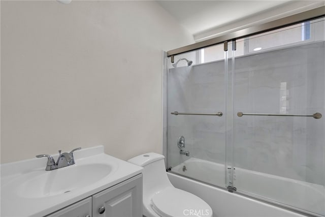 full bathroom with vanity, shower / bath combination with glass door, and toilet