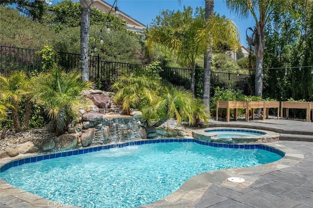 view of swimming pool with a pool with connected hot tub and fence