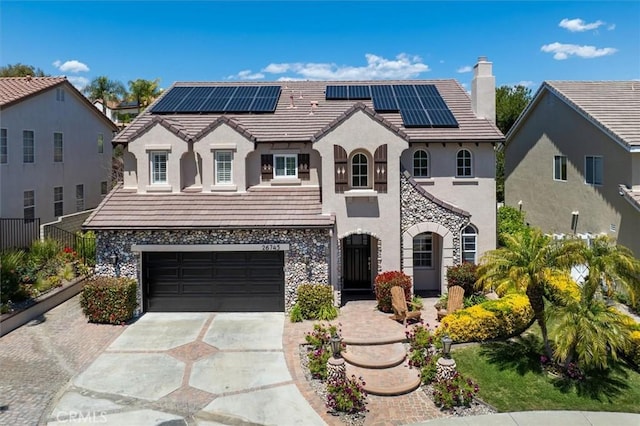 view of front of home with solar panels, stucco siding, a chimney, and concrete driveway