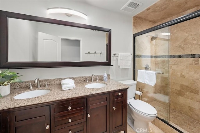 bathroom featuring visible vents, a sink, a stall shower, and toilet