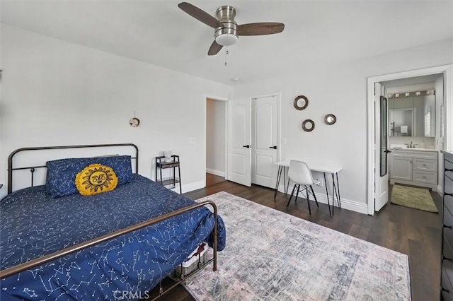 bedroom with a sink, baseboards, and wood finished floors