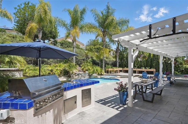 view of pool featuring exterior kitchen, a patio area, a sink, a pergola, and a grill