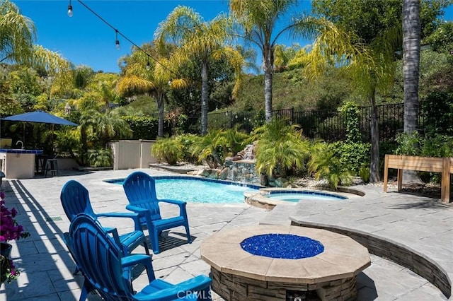 view of swimming pool featuring fence, outdoor dry bar, a patio, and a pool with connected hot tub