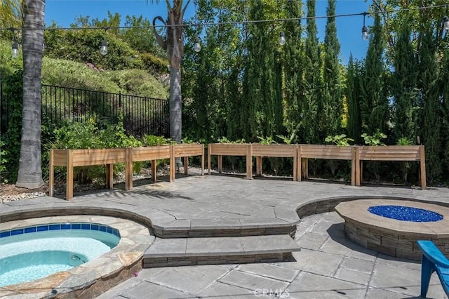 view of swimming pool with a patio, an in ground hot tub, fence, and a fire pit