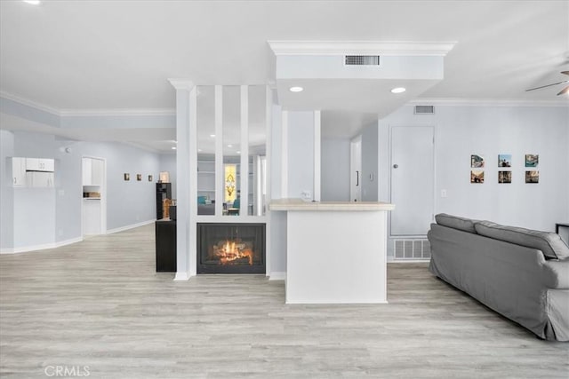 5216 Yarmouth Ave Unit 106, Encino, CA 91316 - living area with visible vents, ornamental molding, light wood-style floors, a warm lit fireplace, and a ceiling fan