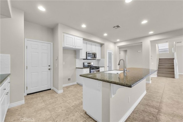 9058 Chimney Rock Ave, Hesperia, CA 92344 - kitchen featuring visible vents, a sink, white cabinetry, dark stone counters, and appliances with stainless steel finishes