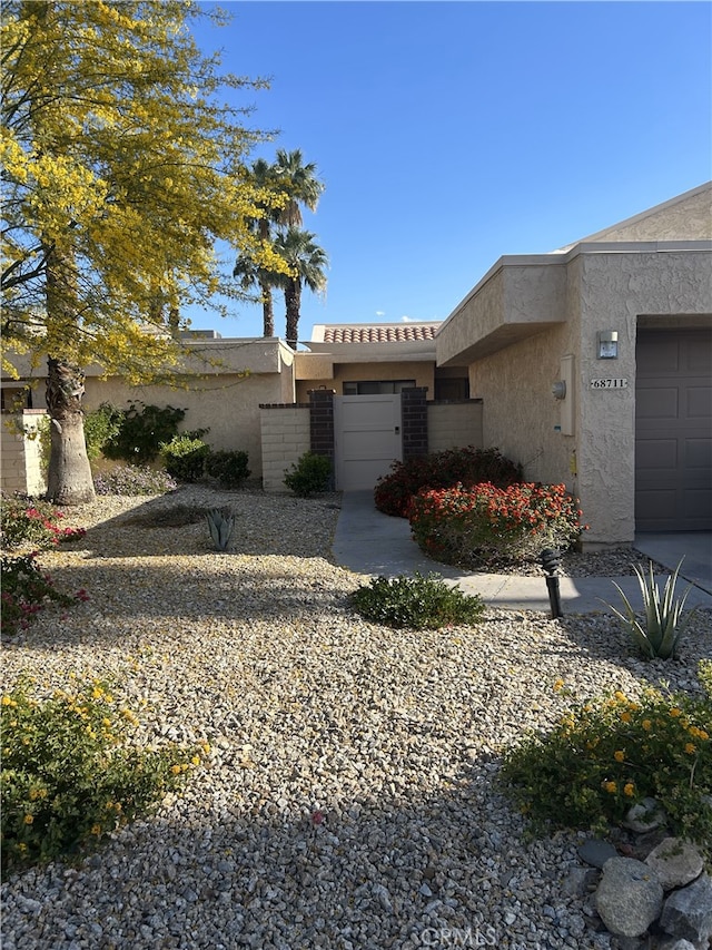 68711 Paseo Soria, Cathedral City, CA 92234 - view of front of property featuring stucco siding, an attached garage, and a fenced front yard