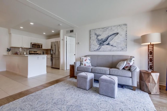 living area with baseboards, recessed lighting, light tile patterned flooring, and visible vents