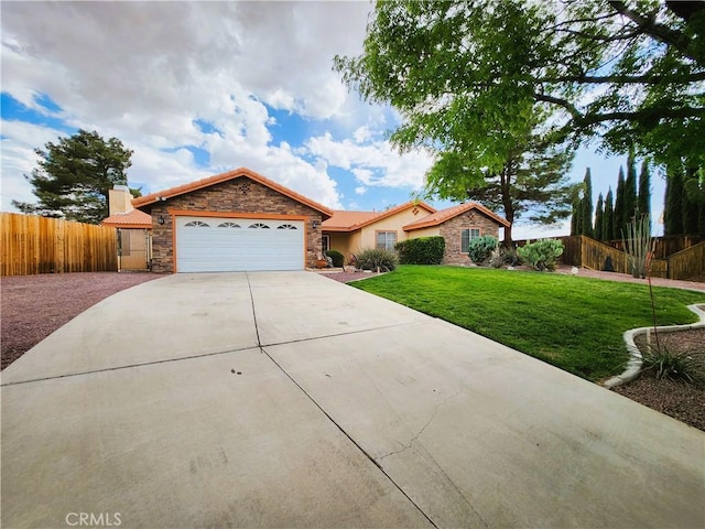 view of front of home with driveway, fence, a garage, stone siding, and a front lawn