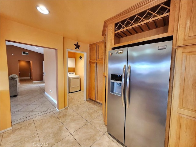 kitchen with stainless steel fridge with ice dispenser, visible vents, baseboards, washer / dryer, and light tile patterned flooring