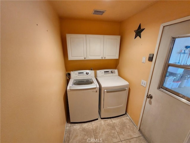 laundry area with independent washer and dryer, baseboards, light tile patterned flooring, visible vents, and cabinet space