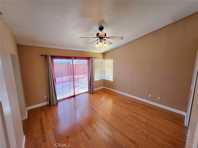 spare room with light wood finished floors, baseboards, and a ceiling fan