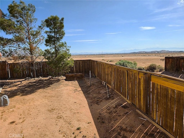 view of yard with a mountain view and fence
