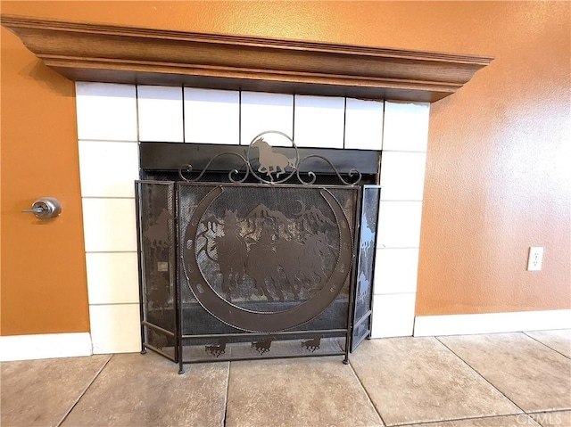 interior details with baseboards and a tile fireplace