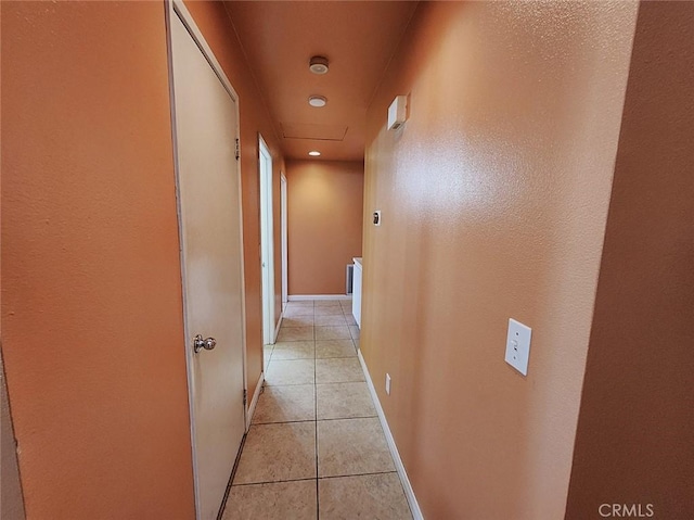 hallway with light tile patterned floors and baseboards