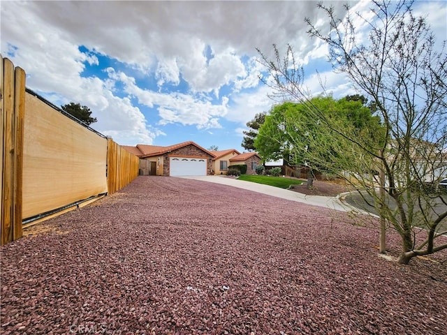exterior space featuring fence, a garage, and driveway