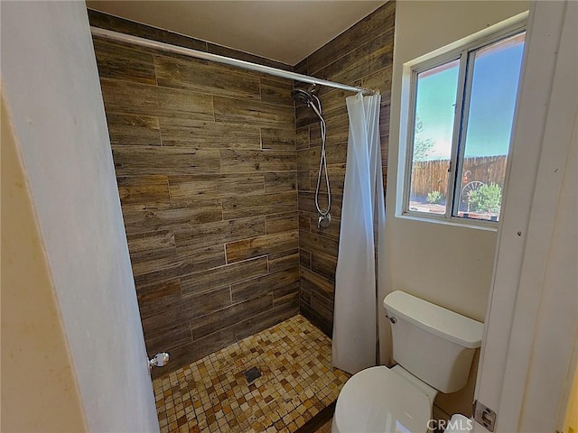 bathroom featuring toilet and tiled shower
