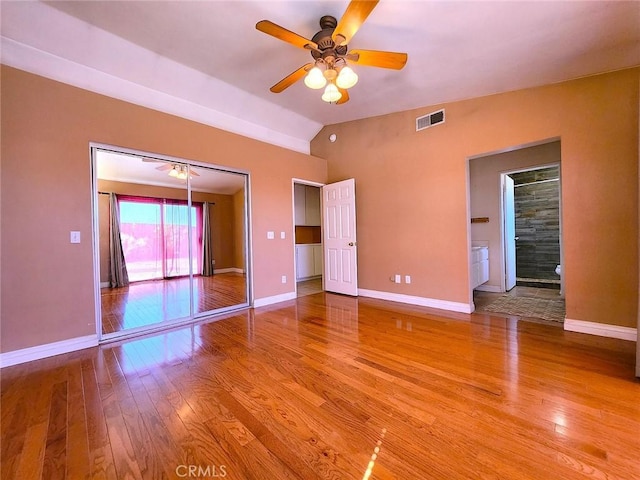 unfurnished bedroom with light wood-type flooring, visible vents, baseboards, ceiling fan, and vaulted ceiling