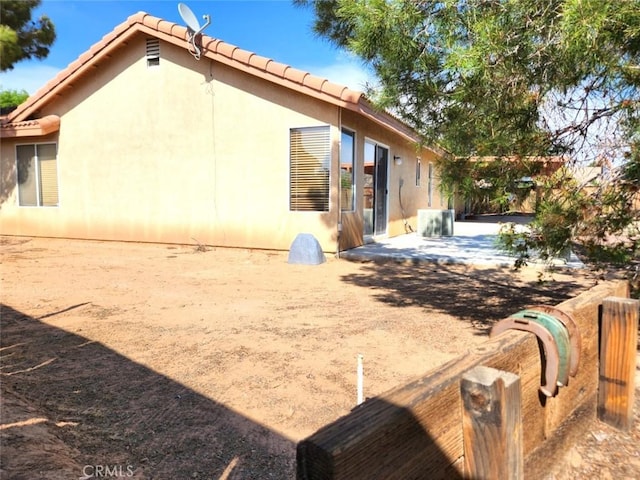 back of property with a patio area, stucco siding, and a tiled roof