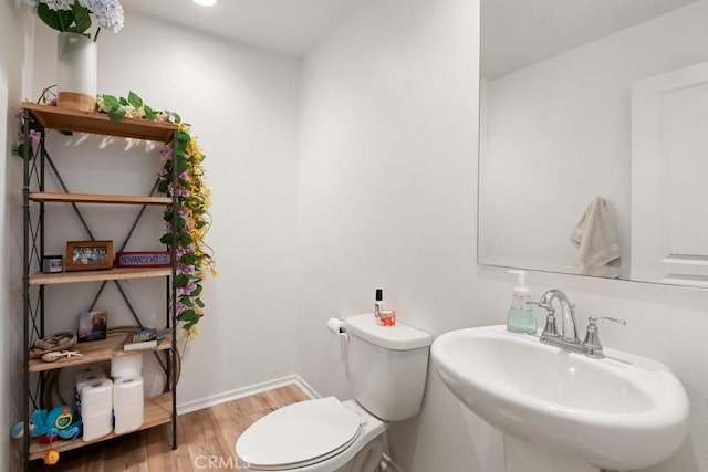 24060 Raptor Way, Lake Elsinore, CA 92532 - bathroom featuring wood finished floors, toilet, a sink, and baseboards