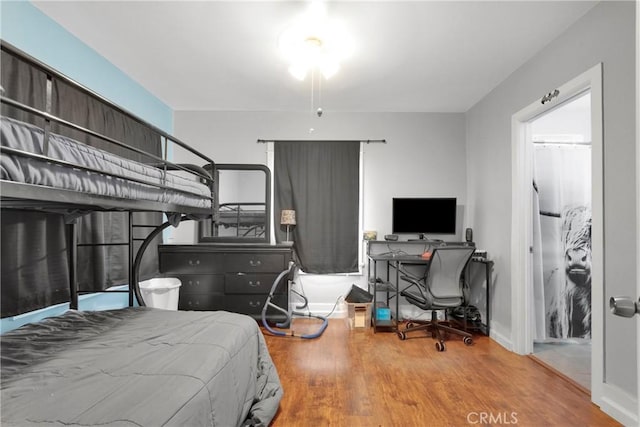 bedroom with baseboards and wood finished floors