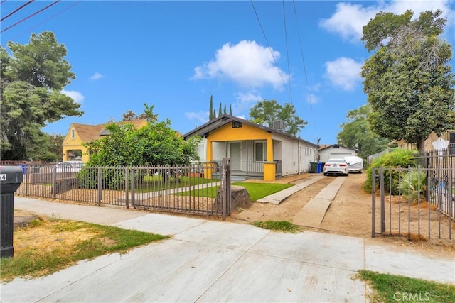 bungalow featuring a fenced front yard, concrete driveway, and stucco siding