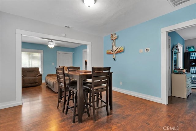 dining area featuring baseboards, wood finished floors, and visible vents