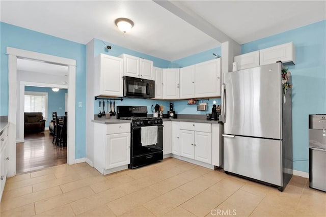 kitchen featuring baseboards, white cabinetry, black appliances, and dark countertops