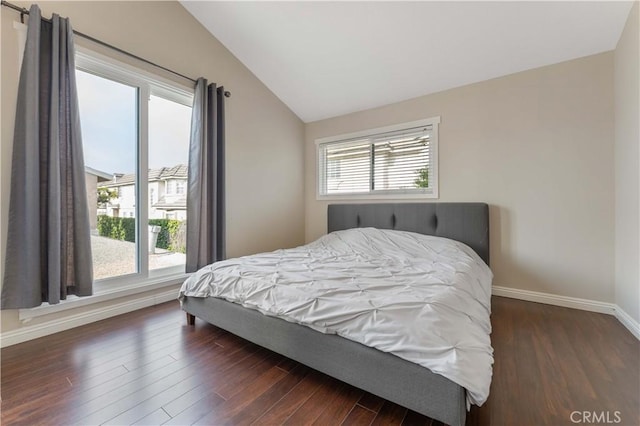 bedroom featuring baseboards, dark wood finished floors, and lofted ceiling