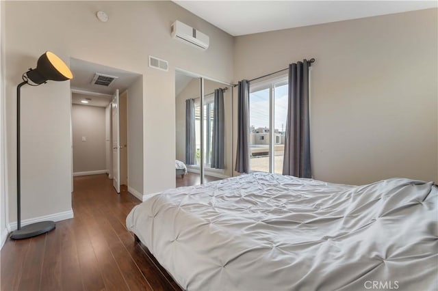 bedroom featuring baseboards, a closet, a wall mounted air conditioner, and visible vents